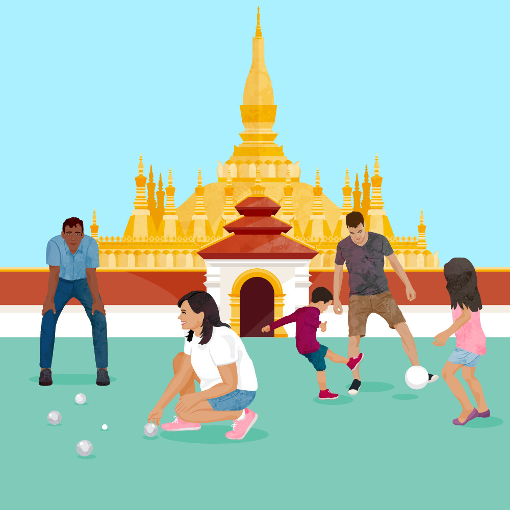 Family playing games in front of temple in in Laos